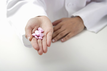 Hand of doctor holding pills