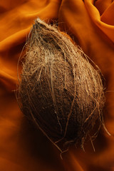 coconut with shell on top of draped cloth