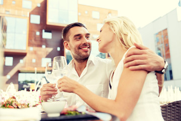 happy couple drinking wine at open-air restaurant