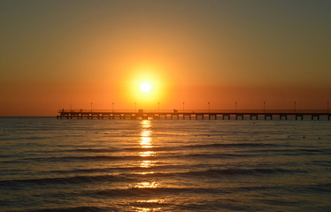 Sea pier in Black Sea resort village in evening at sunset
