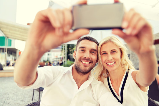 couple taking selfie with smatphone at restaurant
