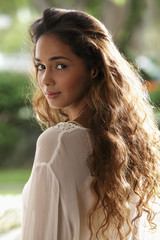 Naklejka premium Young woman with long hair looking over her shoulder