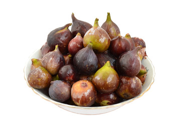 Big white deep dish with gilt edge, fully ripe berries of juicy ripe figs. Isolated on white background, closeup