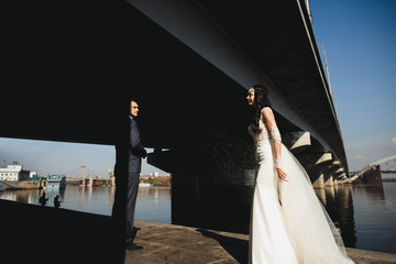 happy  groom and his amazing  bride   walk by the river