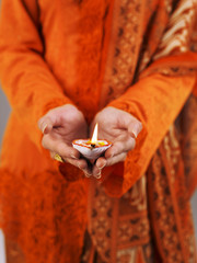 cupped hands holding oil lamp
