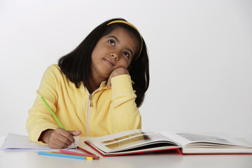 Girl working with color pencils and book