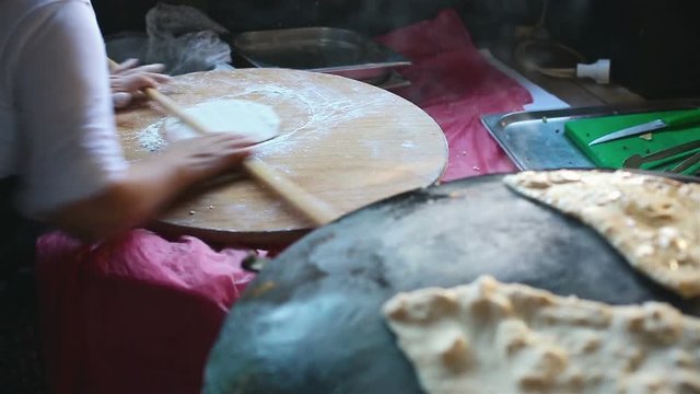 Granny chef cook Turkish pancake Gozleme on the stove