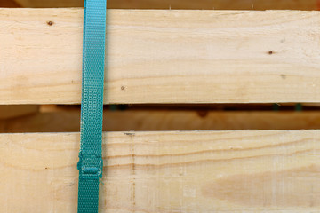 Green plastic strap with wooden planks behind.
