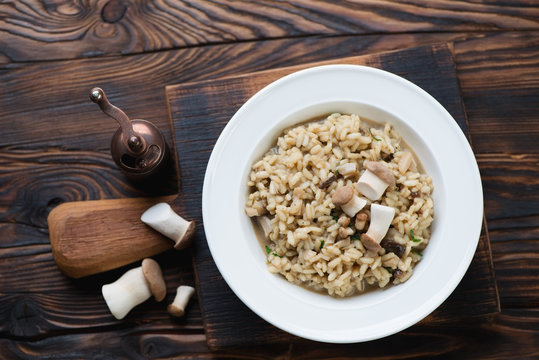 Risotto with porcini over rustic wooden background, top view