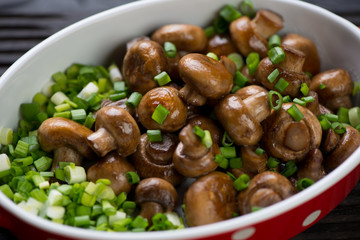 Close-up of roasted champignons served with green onion