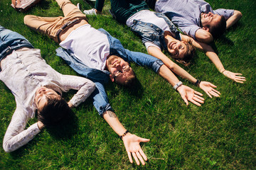 four students lying on the grass