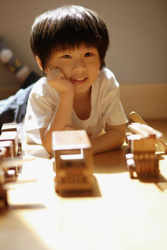 Young boy with hands on chin, looking at camera