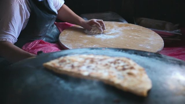 Granny chef cook Turkish pancake Gozleme on the stove