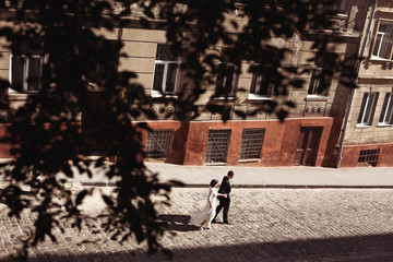 lovely wedding couple is walking down the street