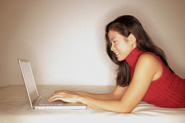 Woman using laptop, profile