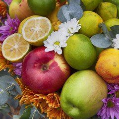 Autumn composition decorating the counter. Apples, quinces and lemons, together with eucalyptus and daisies on the table