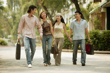 Young men and women walking hand in hand