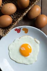 Fried egg on cooked rice and fresh eggs.