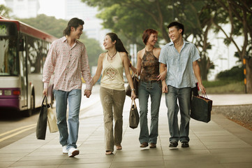 Couples walking together, carrying shopping bags