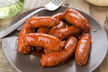 grilled sausage on brown porcelain dish on wood