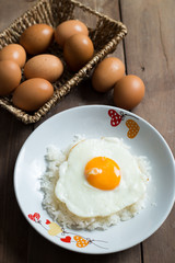 Fried egg on cooked rice and fresh eggs.
