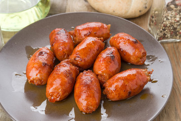 grilled sausage on brown porcelain dish on wood