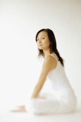 Young woman sitting on floor, looking at camera