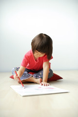 Naklejka premium Young girl drawing on drawing pad.