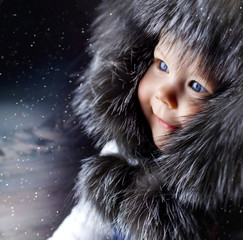 child in a fur hat smiling