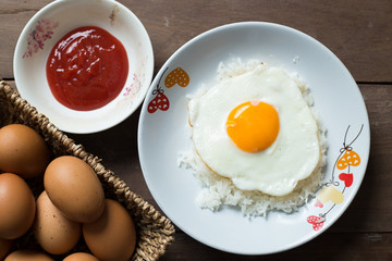 Fried egg on cooked rice and fresh eggs.
