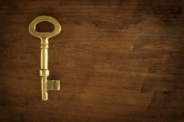Old brass keys placed on a wooden floor low key light.