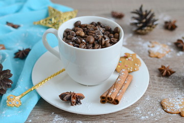Cup of coffee beans with christmas decorations on wooden table
