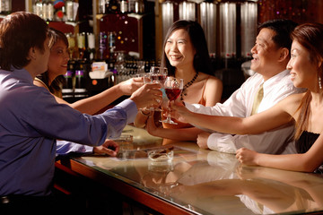 Men and women sitting around table toasting