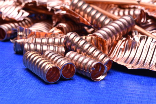 Scrap of copper for recycling on blue background, copy space
