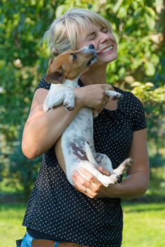 Hund schleckt junge Frau ab