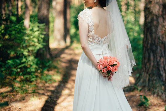 bride in white dress on nature with flowers