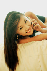Fototapeta premium Young woman on mobile phone, looking at camera