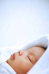 Fototapeta na wymiar Baby wrapped in blanket, sleeping, head shot