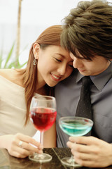 Couple sitting side by side, woman leaning on man