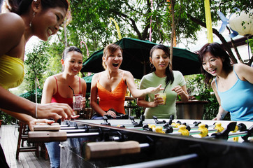 Young women playing foosball, low angle view