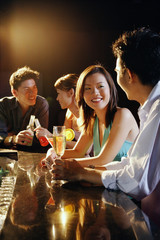 Young adults sitting at bar, talking
