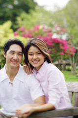 Obraz premium Couple looking at camera, sitting side by side