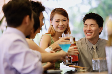 Young adults at bar counter, with drinks