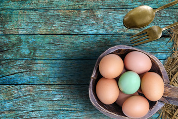 Green egg and the usual in wooden bowl on wooden