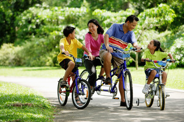 Family in park, riding bicycles