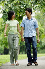 Couple holding hands and walking in park