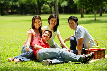 Young adults sitting in park, looking at camera