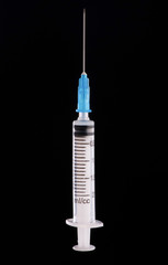 one medical syringe in an upright position on a dark blue background