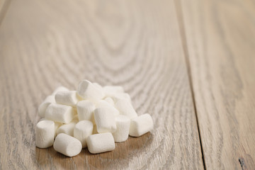 Fototapeta na wymiar white marshmallows on wooden table