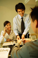Executives having a discussion, woman using mobile phone